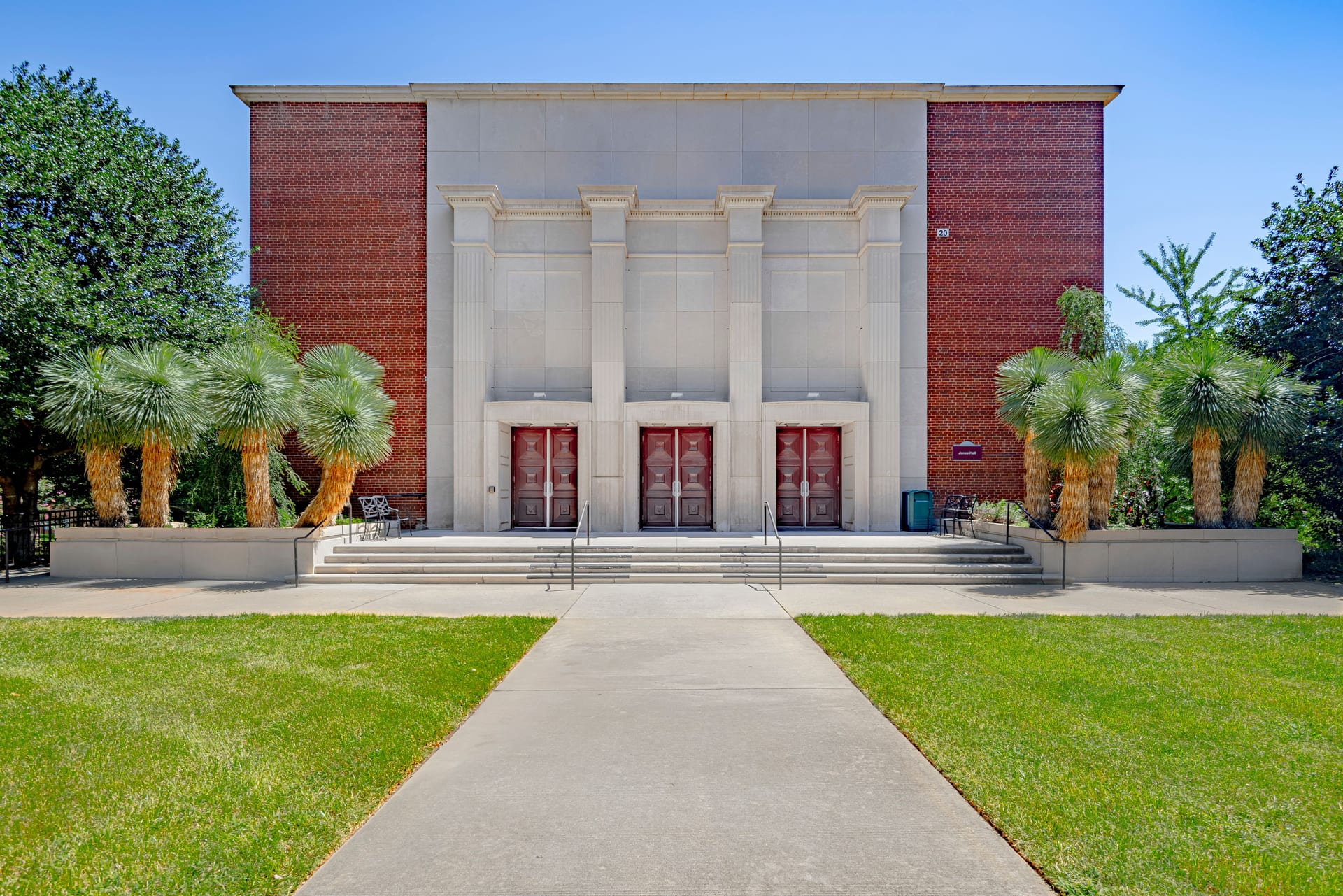 Jones Hall at Meredith College: brick and stone facade with three pairs of red doors, front steps and lawn