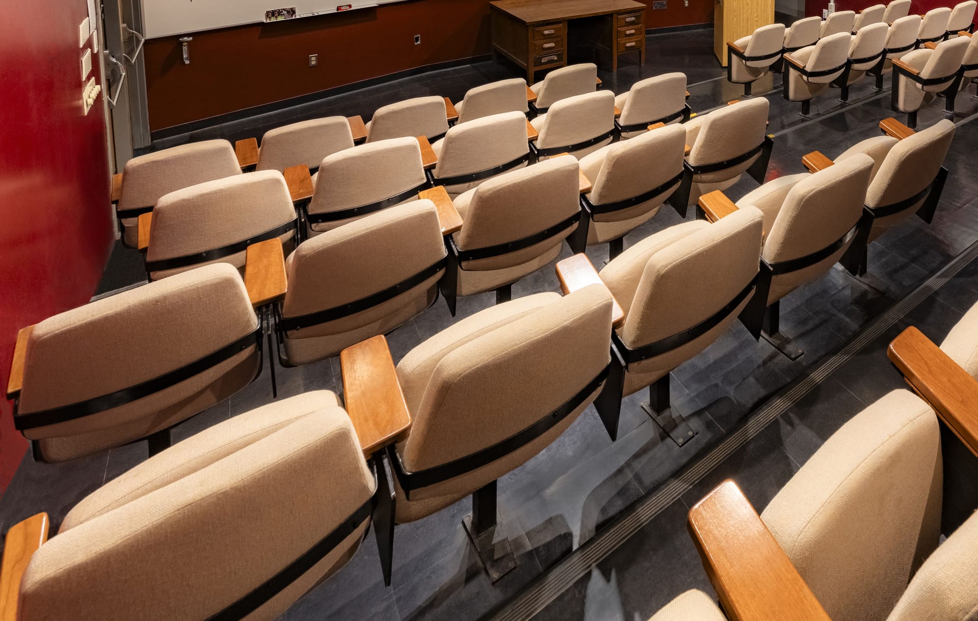 Tiered rows of upholstered seats with wooden armrests in Jones 125